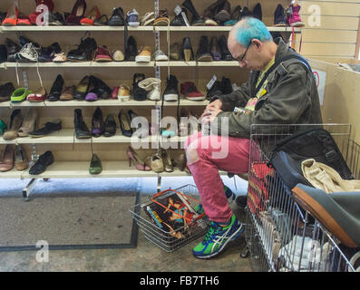 Charity Shop Mann Einkaufen in Oxfam.   Mann mit gefärbten Haaren Stockfoto