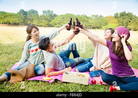 glückliche junge Freunde, Picknick und Bier zu trinken Stockfoto