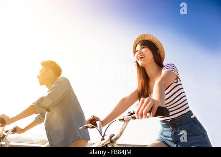 Glückliches junges Paar geht für Fahrrad fahren an einem sonnigen Tag Stockfoto