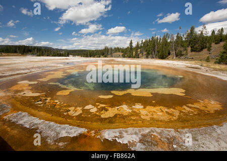 Bunten orangenen und blauen Wasser in chromatischer Pool Hot Springs unter einem sonnigen blauen Himmel in der Upper Geyser Basin von Yellowstone. Stockfoto