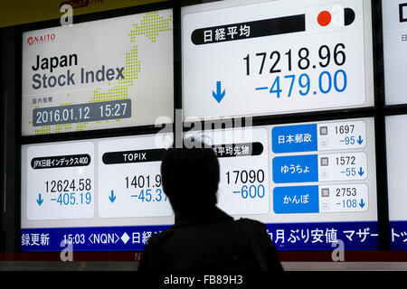 Tokio, Japan. 12. Januar 2016. Ein Fußgänger schaut ein Lager Elektronikplatine zeigt Japans Nikkei Stock Average, die 2,7 Prozent auf 17,218.96 auf 12. Januar 2016, Tokyo, Japan fallen gelassen. Die japanischen Aktien fiel am Dienstag stürzen die Rohölpreise und Premierminister Shinzo Abe Kommentare über Steuererhöhungen im Parlament. Bildnachweis: Rodrigo Reyes Marin/AFLO/Alamy Live-Nachrichten Stockfoto