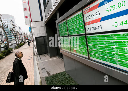 Tokio, Japan. 12. Januar 2016. Ein Fußgänger schaut ein Lager Elektronikplatine zeigt Japans Nikkei Stock Average, die 2,7 Prozent auf 17,218.96 auf 12. Januar 2016, Tokyo, Japan fallen gelassen. Die japanischen Aktien fiel am Dienstag stürzen die Rohölpreise und Premierminister Shinzo Abe Kommentare über Steuererhöhungen im Parlament. Bildnachweis: Rodrigo Reyes Marin/AFLO/Alamy Live-Nachrichten Stockfoto