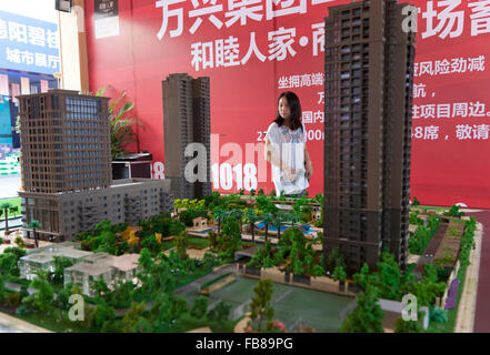 Ein Besucher auf einer Messe in China checkt das Modell einer gemischten Wohn- und Immobilienentwicklung. Stockfoto