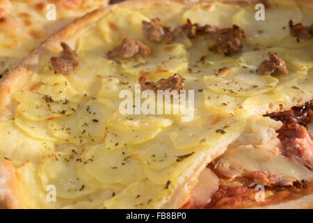 hausgemachte Pizza mit Wurst und Kartoffeln in kleine Stücke schneiden Stockfoto