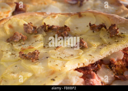 hausgemachte Pizza mit Wurst und Kartoffeln in kleine Stücke schneiden Stockfoto