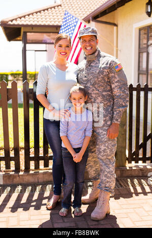 fröhliche junge militärische Familien stehen vor ihrem Haus zusammen Stockfoto