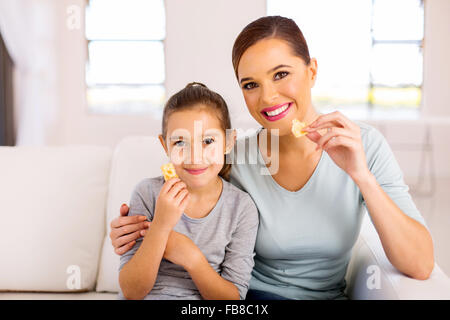 schöne Mutter und Töchterchen Kekse zu Hause essen Stockfoto