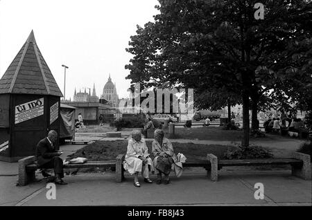 Blick auf Bupapest zum Zeitpunkt der neunziger Jahre. -1990 - Ungarn / Budapest - Blick auf Bupapest zum Zeitpunkt der neunziger Jahre. -Alltägliche Szene. Zwei Freunde sind auf einer Bank sprechen. Die Architektur des ungarischen Parlaments im Hintergrund können wir bemerken.   -Philippe Gras / Le Pictorium Stockfoto