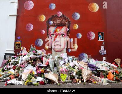 London, Großbritannien. 12. Januar 2016. Blumen und Nachrichten, die von Fans sind bei einem David Bowie-Wandgemälde in Brixton, South London, Großbritannien, am 12. Januar 2016 sehen. Bildnachweis: Han Yan/Xinhua/Alamy Live-Nachrichten Stockfoto