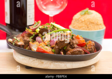 Lomo Saltado - ein sehr beliebtes Gericht in Peru gebratenes Rindfleisch mit einer Beilage von Tacu Taco Reis Stockfoto