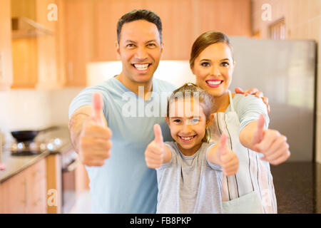 glückliche Familie aufgeben Daumen in Küche Stockfoto