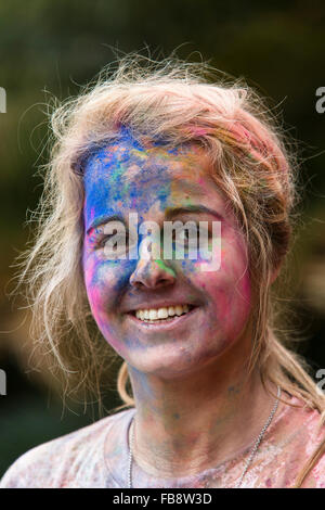 Ziemlich junges Mädchen mit ihrem Gesicht spritzte mit bunten Farbe nach der Teilnahme an der Farbe Run Stockfoto