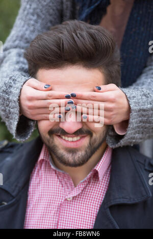 Frau schließen den Augen des Mannes Stockfoto