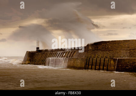 Sturm-Desmond trifft Porthcawl und Absturz über den Leuchtturm und Mole in Süd-Wales, UK. Stockfoto