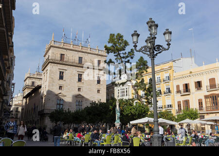 Touristen saßen in La Plaza De La Virgen, im Hintergrund El Palacio De La Generalidad, Valencia, Spanien. Stockfoto