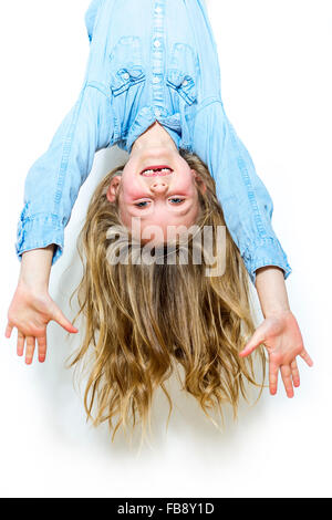 Lächelnde junge Mädchen hängt vor weißem Hintergrund Stockfoto