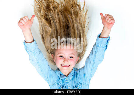 Lächelnde junge Mädchen hängt vor weißem Hintergrund Stockfoto