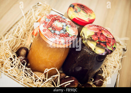 Leckere Marmelade im Glas Gläser mit Kastanien im Heu. Saisonale Gerichte-Thema. Still-Leben. Stockfoto