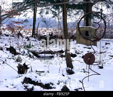 Ungewöhnliche und ausgefallene Fundstücke als Ornamente in einem verschneiten Winter-Garten Stockfoto