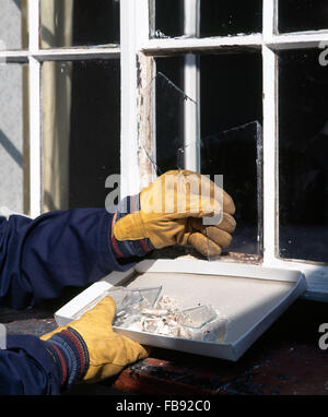 Nahaufnahme der Hand ausschlagen zerbrochenes Fensterglas aus einem frame Stockfoto