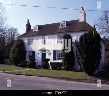 Außen von einem weißen viktorianischen Landhaus mit hohen Eiben auf dem Rasen Stockfoto