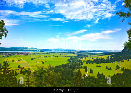 Bayern-Landschaft von Schloss Neuschwanstein. Schwangau-Dorf und Forggensee See im Hintergrund. Stockfoto