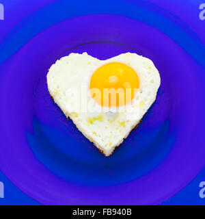 Ei auf blauen Teller in Herzform Stockfoto