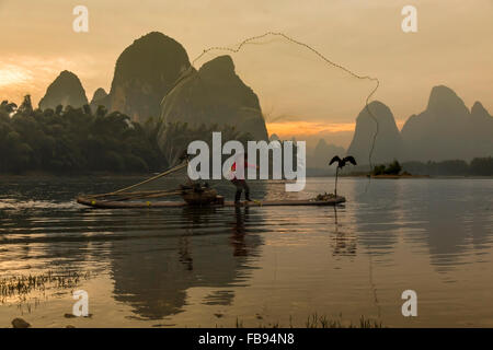 Li-Fluss - Xingping, China. Januar 2016 - ein alter Fischer Fischen mit einem Fischernetz. Stockfoto