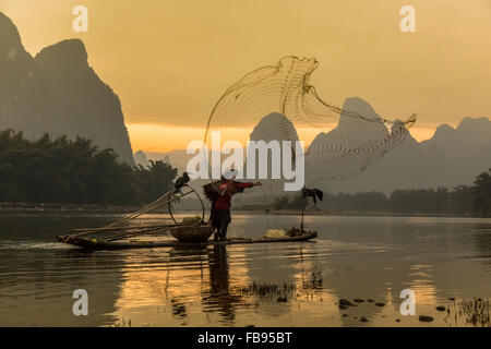 Li-Fluss - Xingping, China. Januar 2016 - ein alter Fischer Fischen mit einem Fischernetz. Stockfoto