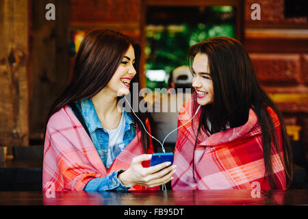 Zwei Mädchen sitzen Musik hören Stockfoto