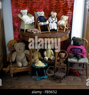 Sammlung von Vintage Teddy Bären auf Konsolentisch und Kinderstühle Stockfoto