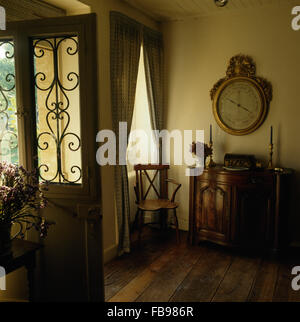 Große antike Barometer über dem antiken Schrank im traditionellen Halle mit Holzboden und eine halbe verglaste Tür mit einem Kühlergrill Stockfoto