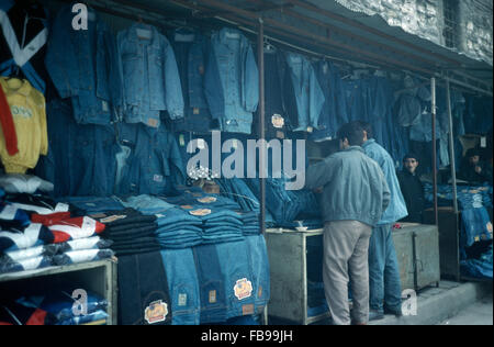 Verkäufer und Kunden zu einem Straßenmarkt stall verkaufen Jeans Herrenbekleidung Stockfoto