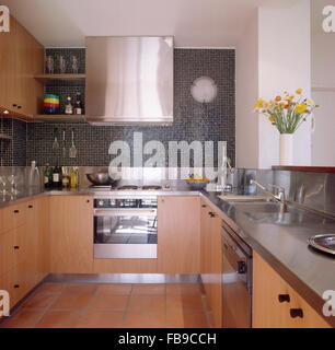 Edelstahl-Dunstabzugshaube und Backofen in der modernen Küche mit Mosaik Wandfliesen Stockfoto