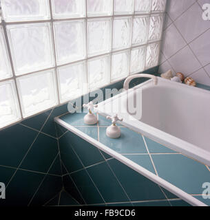 Glas-Ziegel-Fenster über Bad mit Türkis gefliest, Surround und panel Stockfoto