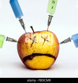 Traurig Apfel mit Spritzen Stockfoto