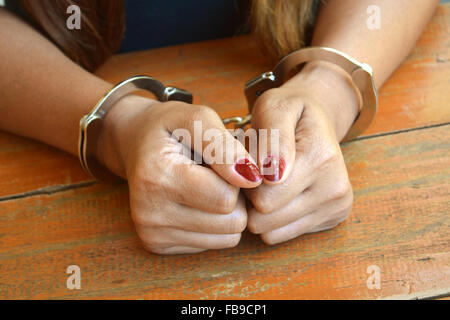 Weibliche Gefangene untersucht mit Händen gefesselt auf einem Tisch Stockfoto