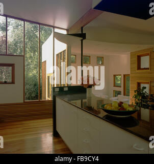 Obstschale auf ausgestattete Sideboard in einer großen offenen architektonischen Halle mit Holzfußboden und großen Fenstern Stockfoto