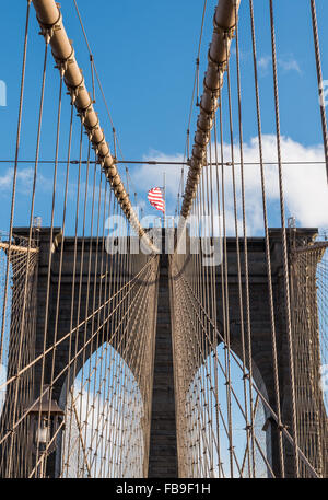 Auf der Suche nach oben auf einen der Türme der Brooklyn Bridge mit Granit und Kalkstein Mauerwerk und Aussetzung Kabel. NEW YORK CITY. Stockfoto