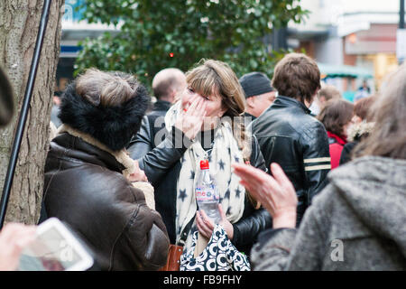 London, UK. 12. Januar 2016. Ventilator abwischen Tränen als Tribute und Nachrichten von anderen liegen unter ein Wandbild von der späten David Bowie. Brixton u-Bahnstation, London, UK. © Martyn Wheatley/Alamy Live News Stockfoto