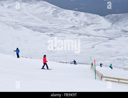 Skifahrer und Snowboarder auf Ski Pisten am Cairngorm Mountain Ski Centre, Schottisches Hochland, Schottland, Vereinigtes Königreich Stockfoto