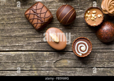 verschiedene Pralinen auf alten Holztisch Stockfoto