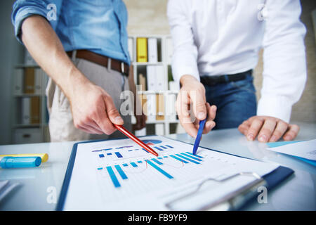 Zwei Kollegen auf Geschäftsdiagramme zeigen Stockfoto