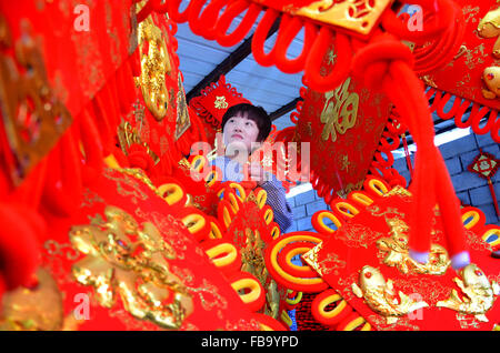 Zibo, Shandong Provinz. 12. Januar 2016. Ein Arbeiter hängt chinesische Knoten bei einem Workshop in Yiyuan County, Ost-China Shandong Provinz, 12. Januar 2016. Chinesische Knoten werden beliebter als Chinas Lunar New Year Ansätze. © Zhao Dongshan/Xinhua/Alamy Live-Nachrichten Stockfoto