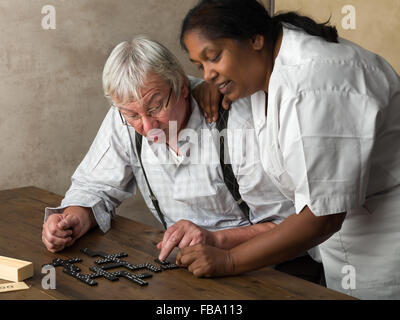 Rentner im Pflegeheim Domino spielen Stockfoto