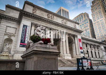 Marmor Löwe Skulptur geschmückt mit Weihnachtsschmuck, The New York Public Library, Manhattan, New York, USA Stockfoto