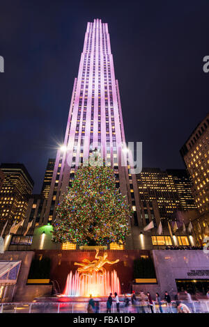 Nachtansicht der Prometheus Bronze Skulptur und der Weihnachtsbaum am Rockefeller Center in Manhattan, New York, USA Stockfoto