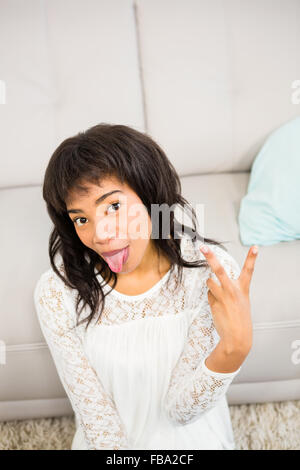 Lässige lächelnde Frau gestikulieren Peace-Zeichen Stockfoto