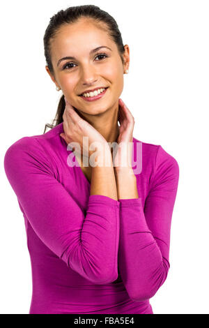 Lächelnde Frau mit Händen am Hals in die Kamera schaut Stockfoto
