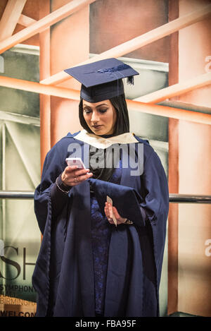 Junge muslimische Frauen Diplomand mit Smartphone, Abschlussfeier Stockfoto